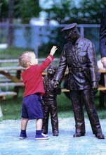 Two year old William Sexton touches statue of his grandfather Det. Alton C. Parker. Photo courtesy of the Windsor Star, August 28, 1997